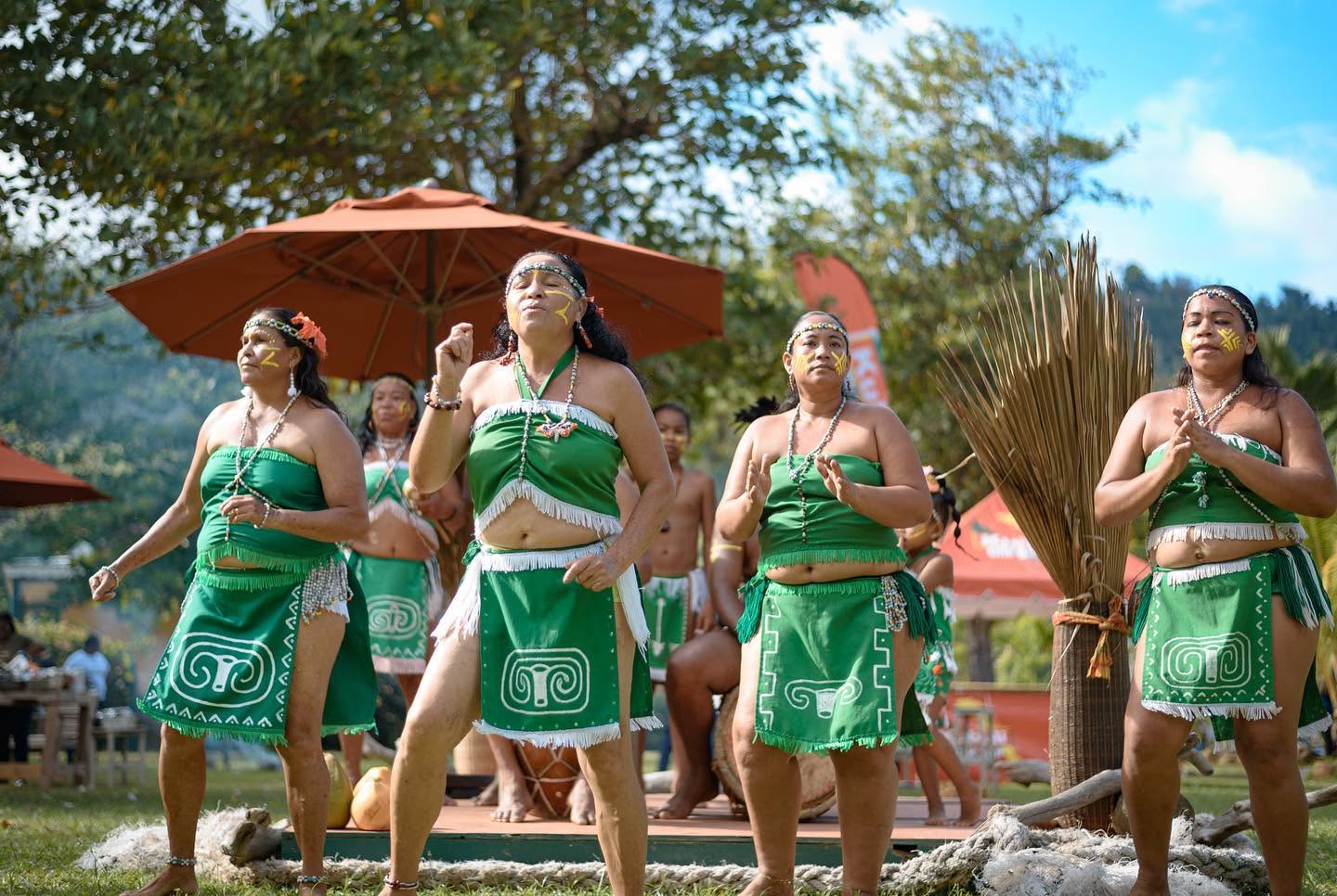 Kalinago women dancing in traditional green dress outdoors