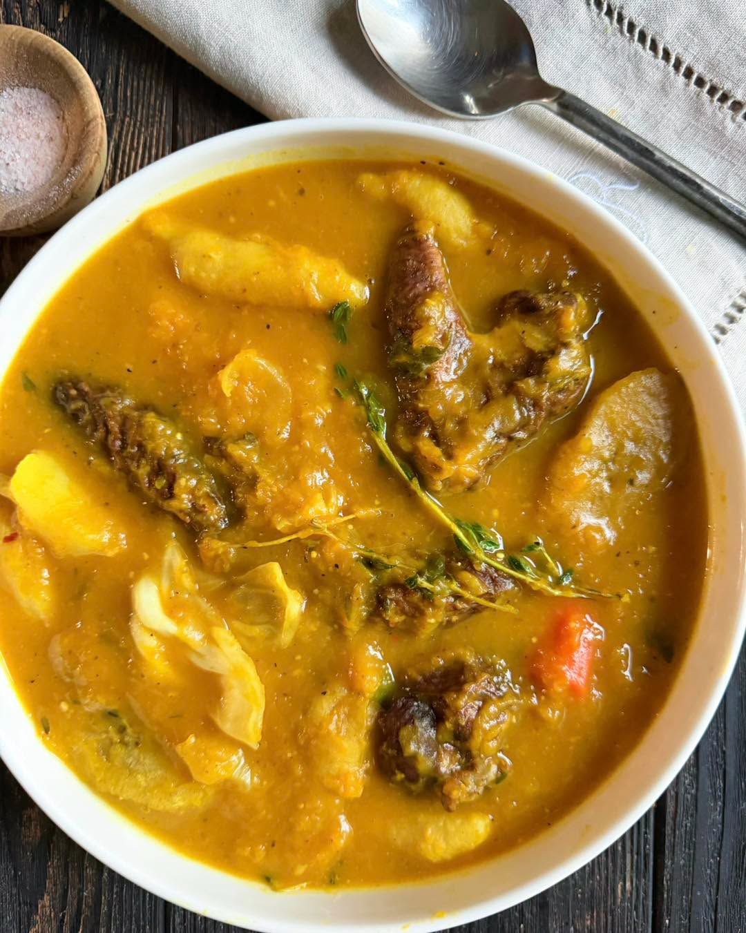 Pumpkin soup with provisions and meat simmering in a bowl